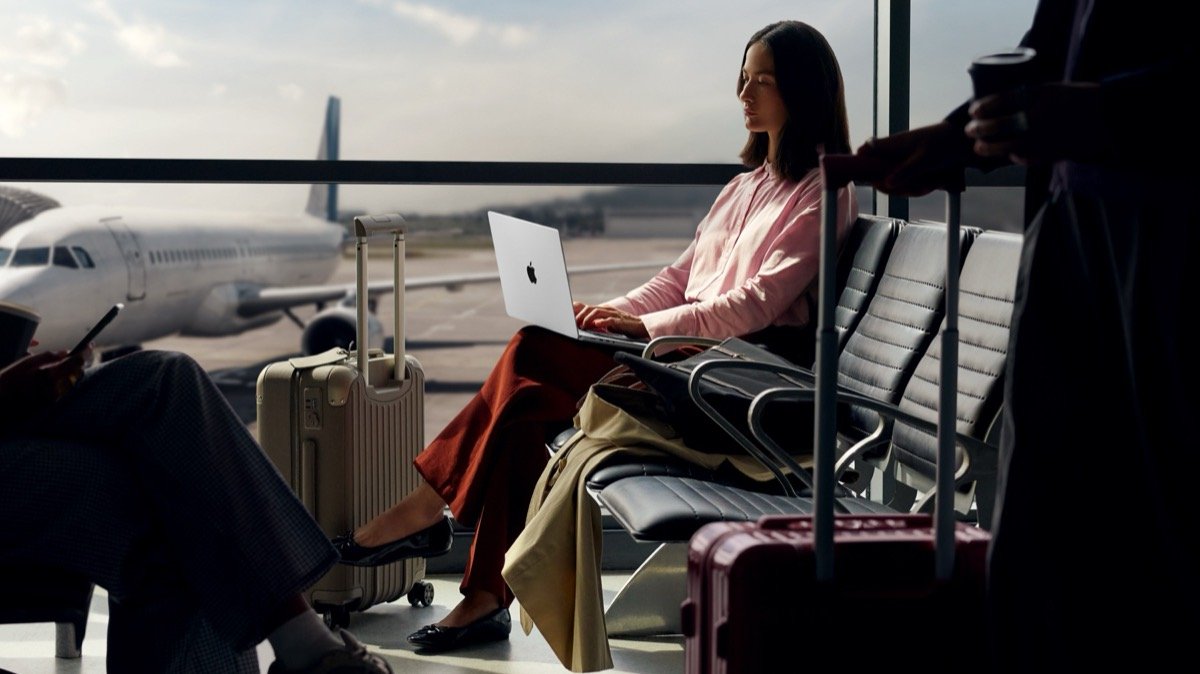 Pessoa trabalhando no MacBook Pro no aeroporto